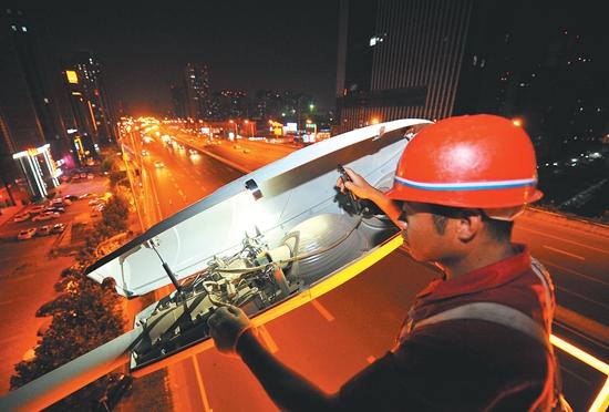 2014年8月20日晚,合肥市政工程人员在检修高架节能灯.